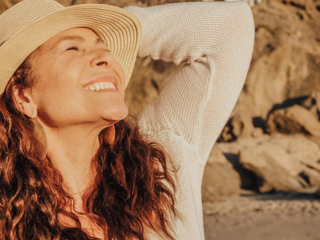 Middle-aged woman smiling outdoors, representing healthy aging and balanced biological age.