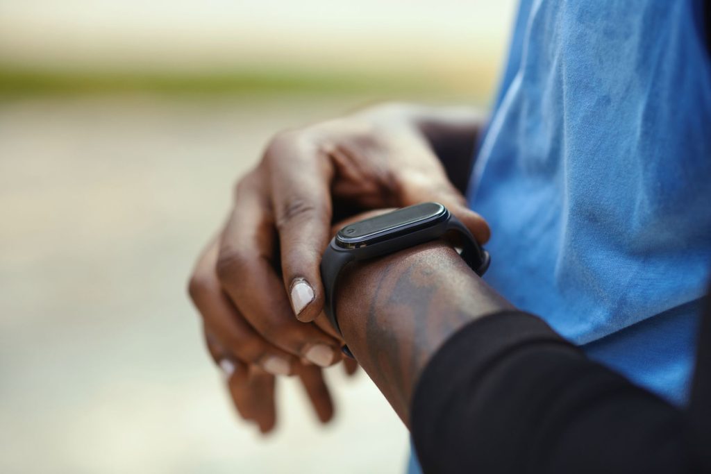 Person checking a fitness tracker while walking, tracking daily steps for better health.